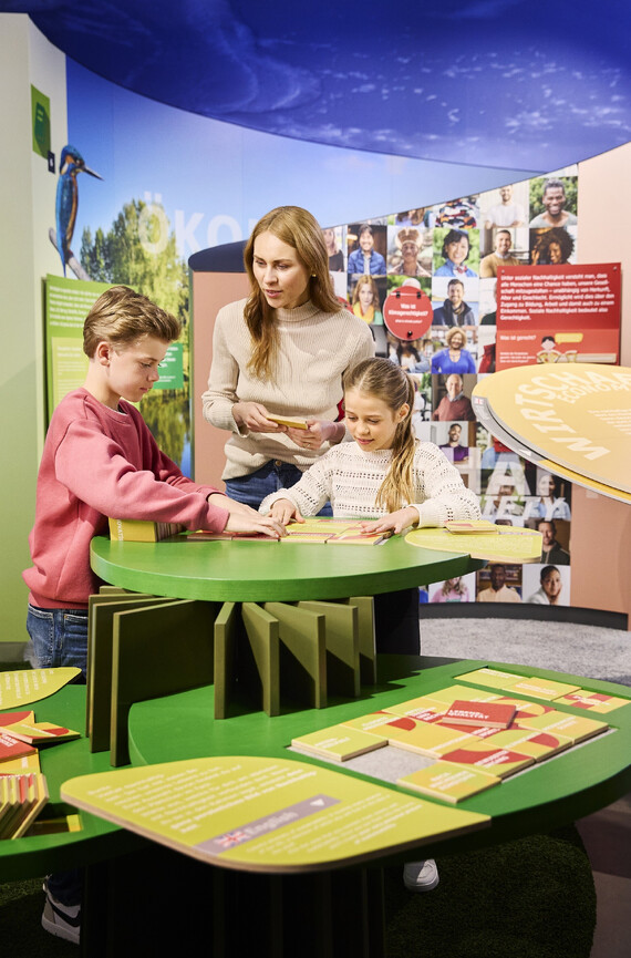 Familie beim Puzzle im Exponat Nachhaltigkeit.
