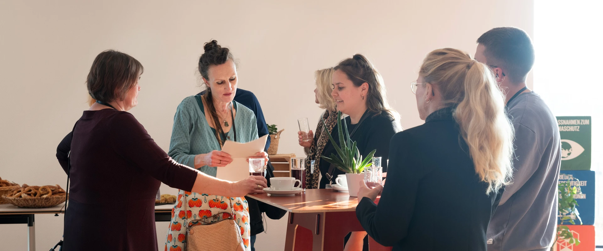 Ein Arbeitsteam steht um einen Tisch und redet miteinander